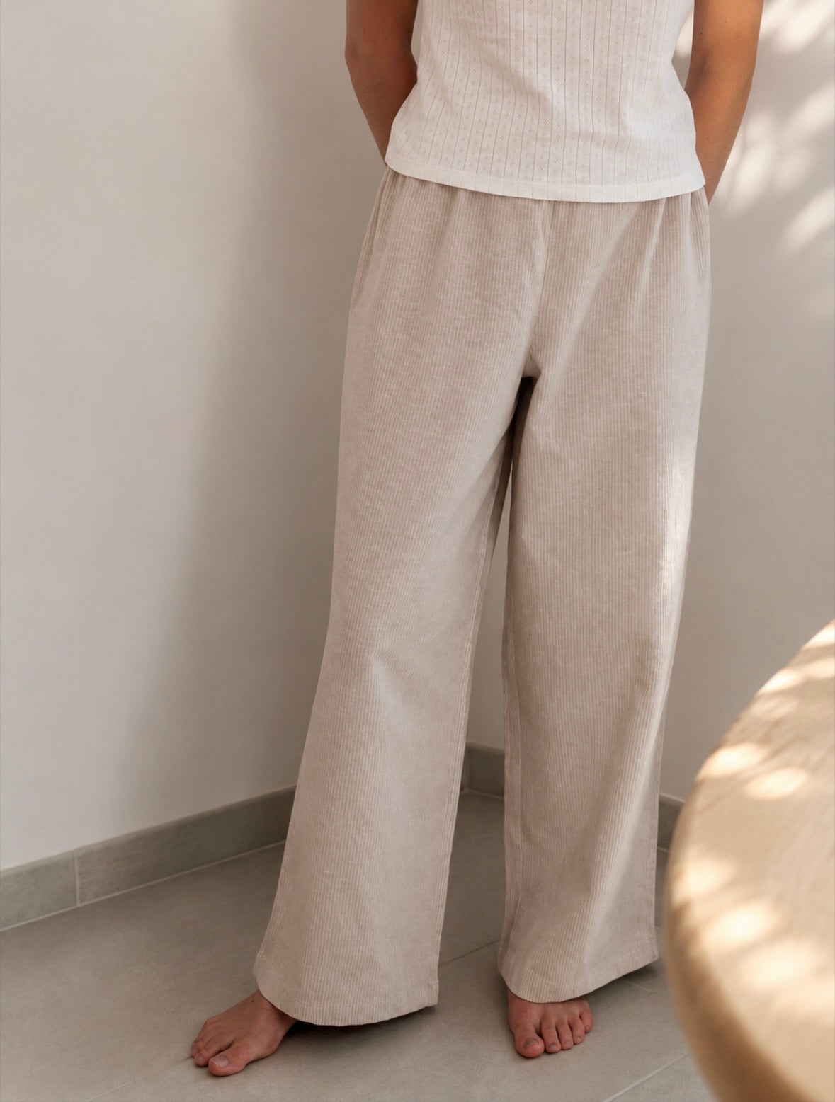 Pantalon de pyjama femme beige en matières 100 % naturelles, coupe large à fines rayures, pyjama confortable et élégant pour l'été.