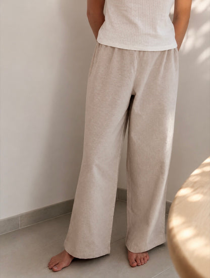 Pantalon de pyjama femme beige en matières 100 % naturelles, coupe large à fines rayures, pyjama confortable et élégant pour l'été.