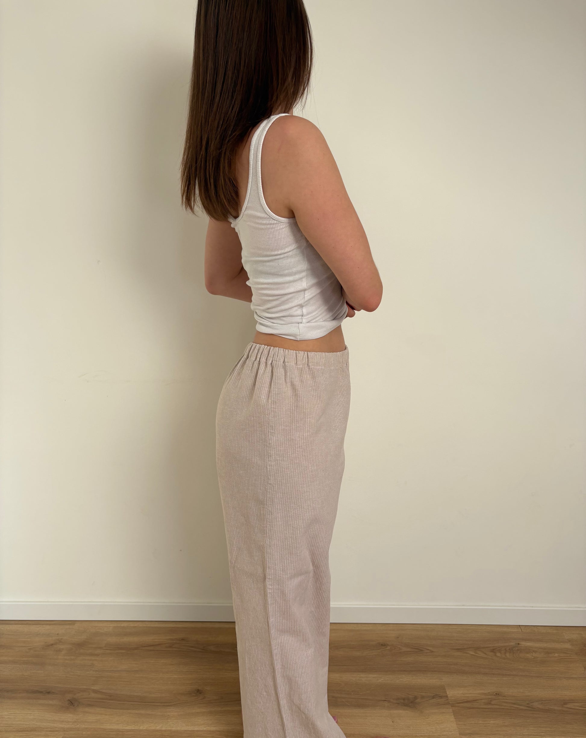 Pantalon de pyjama femme beige en matières 100 % naturelles, coupe large à fines rayures, pyjama confortable et élégant pour l'été.